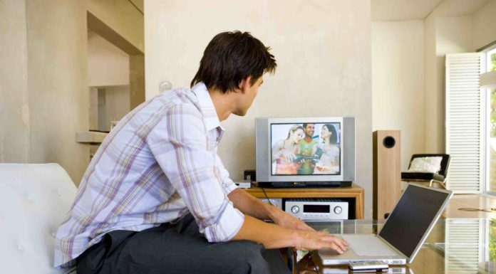 Pacjent zagraniczny w Polsce i jego potrzeby mezczyzna oglada telewizje i pracuje na laptopie